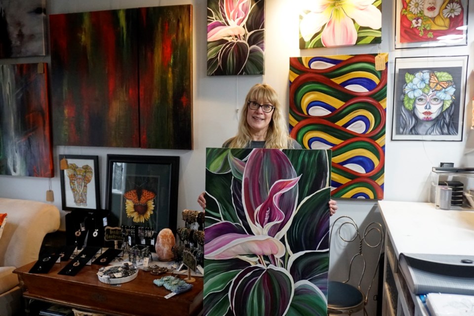 Jackie Wall has a variety of her art in different forms and shapes on display in her studio in Bienfait. Wall is pictured here in her studio holding a painting called Vibrancy, which is also displayed as a vinyl print on the side of Pharmasave in Estevan.                                