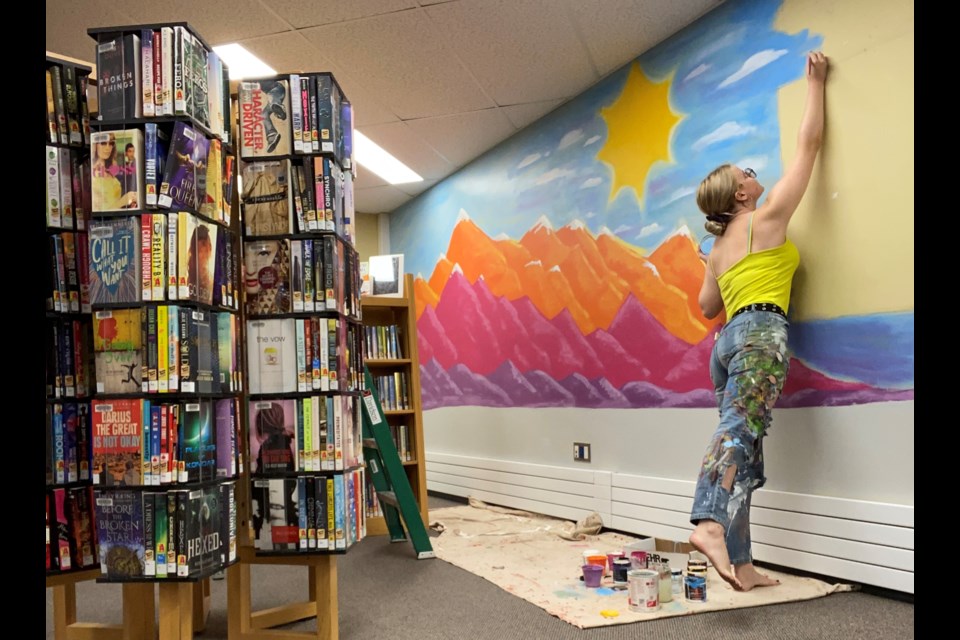 Artist Mya Lauer at work on the mural she painted at Yorkton Public Library.