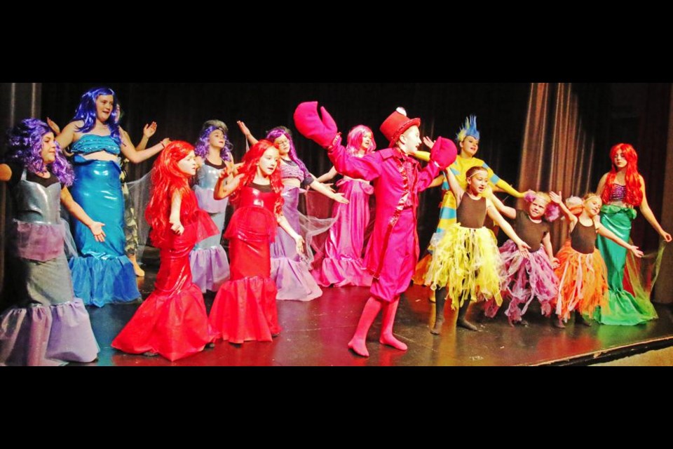 The sea creatures, led by Sebastian the crab (Lila Anderson, centre), sing about how it's better to be "Under the Sea" as Ariel (Brittany Barber) listens at far right.