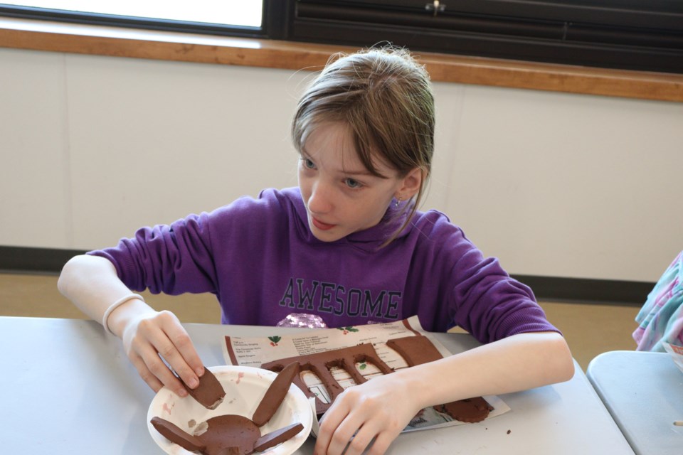 Emily uses clay slip to attached her petals to her flower.