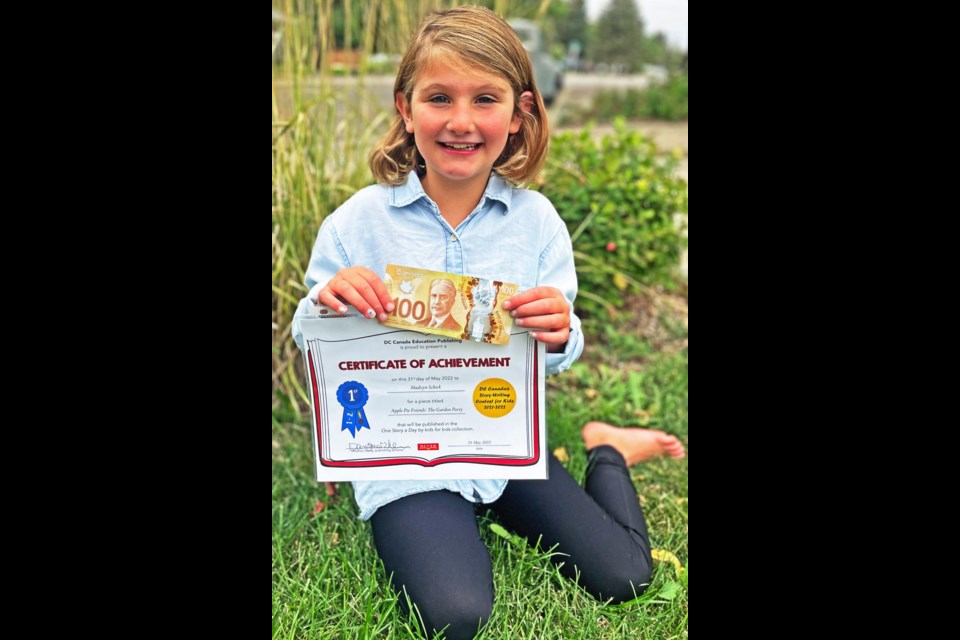 Madisyn Schick holds her prize money and certificate for winning first place in the Gr. 1-2 category for her story about "Apple Pie Friends".