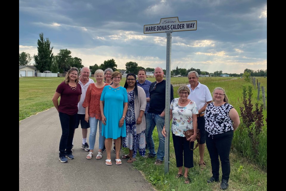 Marie Donais Calder, middle, her family and friends gathered by the new sign at pathways on July 6. 