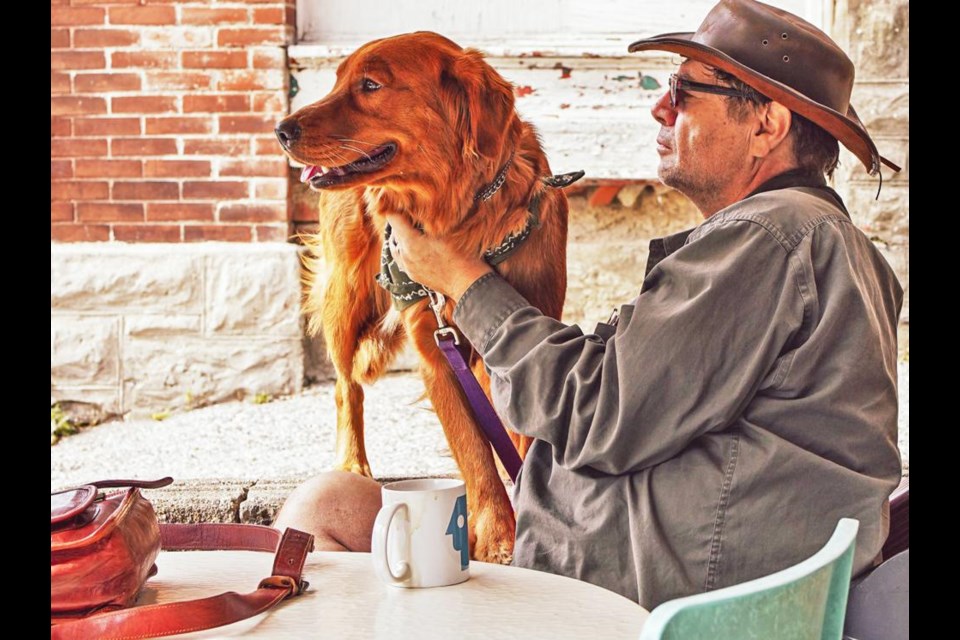 Writer Mark Morton sits at a table at the Yeti Cafe in Kitchener, Ont., with his dog Giaa, and this is one of his favourite places to write. The native of Griffin has just released his first work of fiction, The Headmasters, on Feb. 6, published by Shadowpaw Press, and is a young adult dystopian story. He previously authored four non-fiction books.