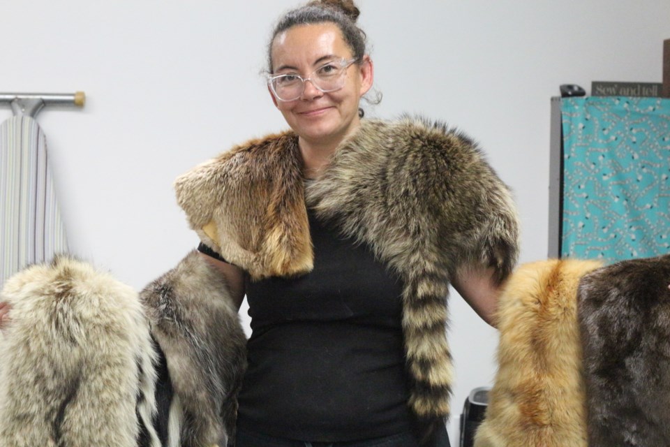 Natasha Aichel, pictured here with several of the many furs she uses to craft moccasins which include fox, raccoon and possum among others.