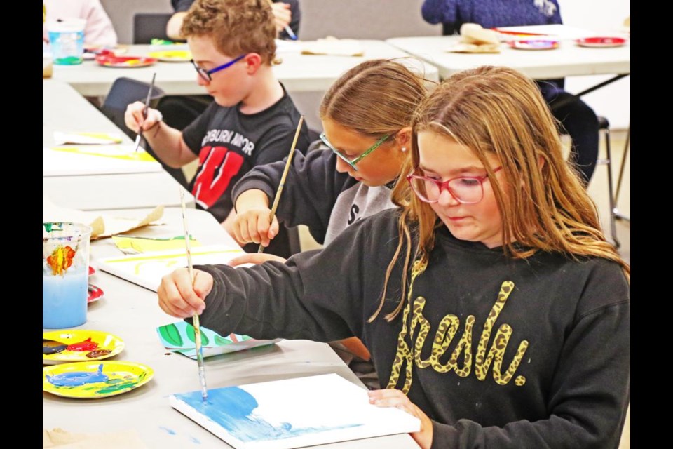 Grade 6 students Hanna Vallier, Maci Jack and Charles Megenbir worked on painting their own squares for a Culture Days mural on Wednesday about a medicine wheel.