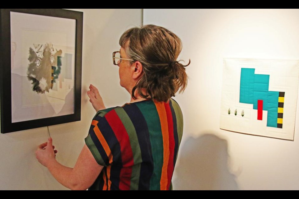 Curator Regan Lanning began setting up the People's Choice entries on Wednesday morning in the Weyburn Art Gallery, in preparation for the exhibit opening on Jan. 5.