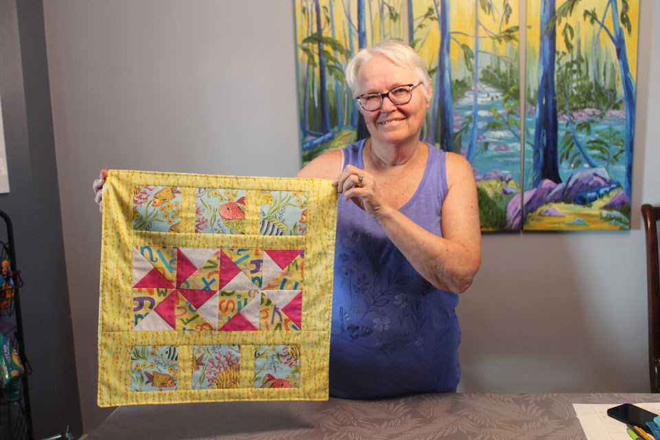 Judy Adkins, showing a quilt that is headed to one of Saskatchewan’s NICUs.