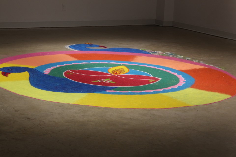 A rangoli of a peacock, the national bird of India, complete with intricate designs.