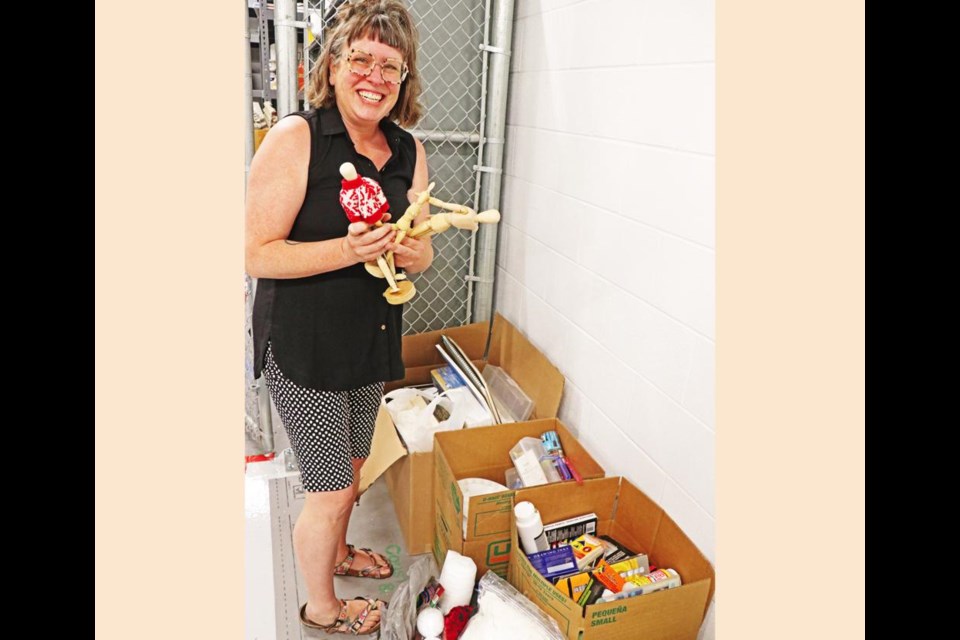 Regan Lanning holds a handful of wooden models that Carol used in teaching children how to draw.