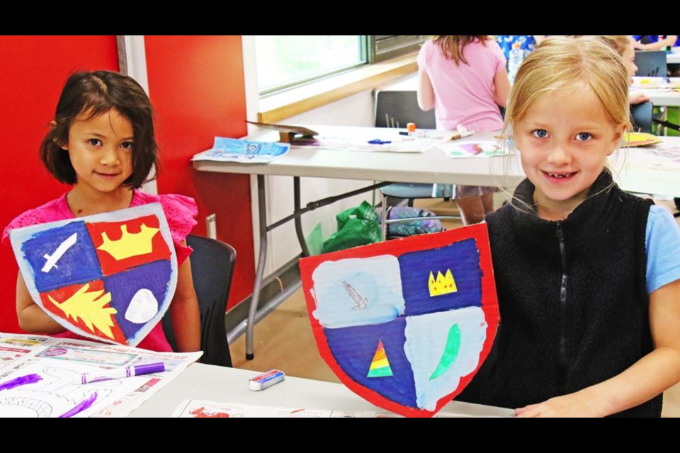 Ava and Tenley showed off the coats-of-arms they created on shields in the summer art/rec program on at the Credit Union Spark Centre on Friday morning.