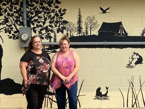 Heather Gawrelitza, right, posed for a photograph with Carrie Olson who finished the wall mural that was painted on the shower building at the Preeceville Wildlife campground.