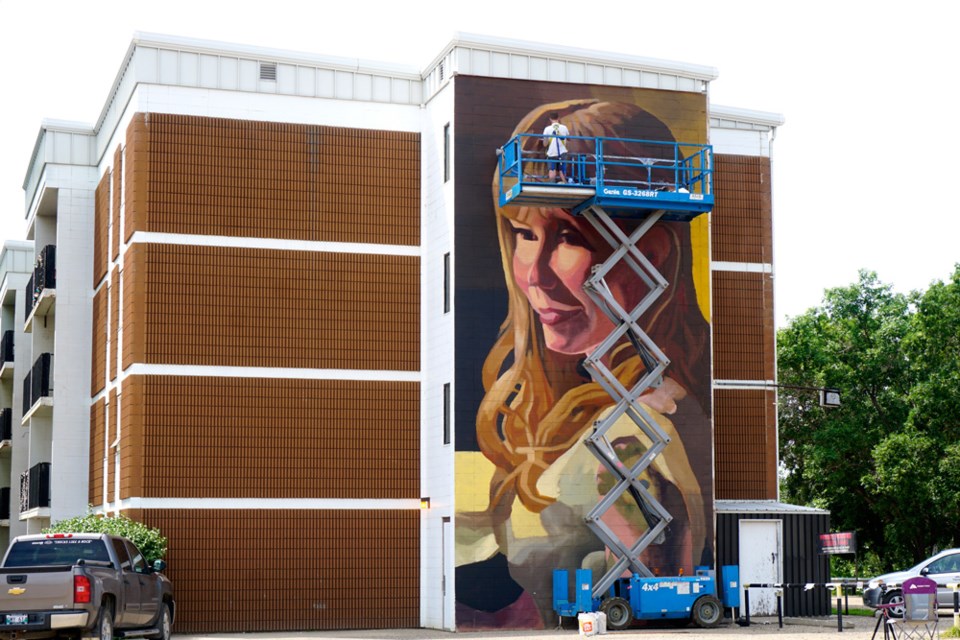 B.J. Zieger is currently working on a big portrait of his wife Keisha Zieger on Sussex Arms apartment building. 
