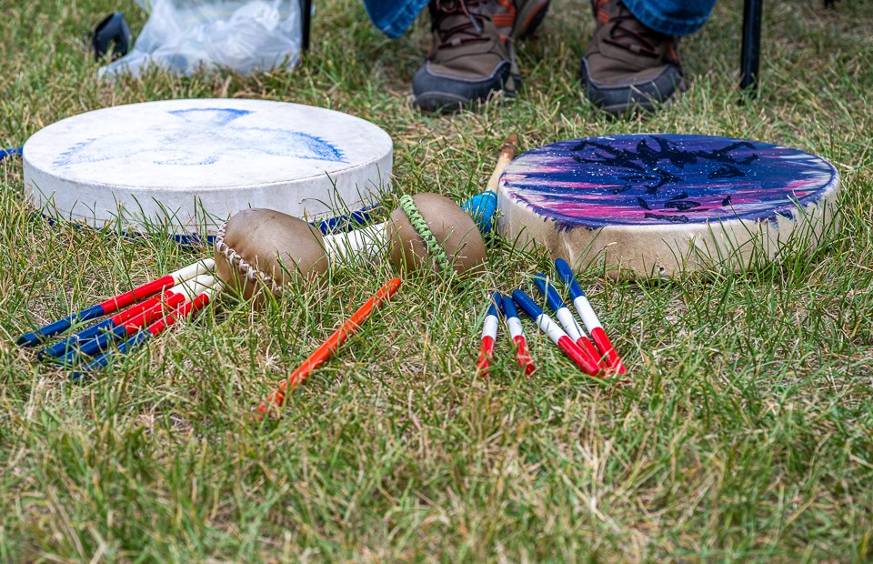 Drums, rattles, main orange stick plus the five colourful sticks for each team are displayed on the grass before the game begins.