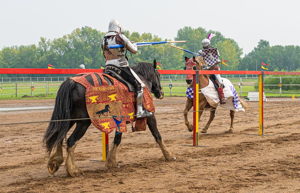 Jousting is a medieval sport featuring two mounted knights using lances to strike each other.  The objective is to strike the opponent with the lance, often aiming for their shield or helmet, and potentially unhorse them. Jousting can be difficult if the horses aren’t trained beforehand to run towards each other.