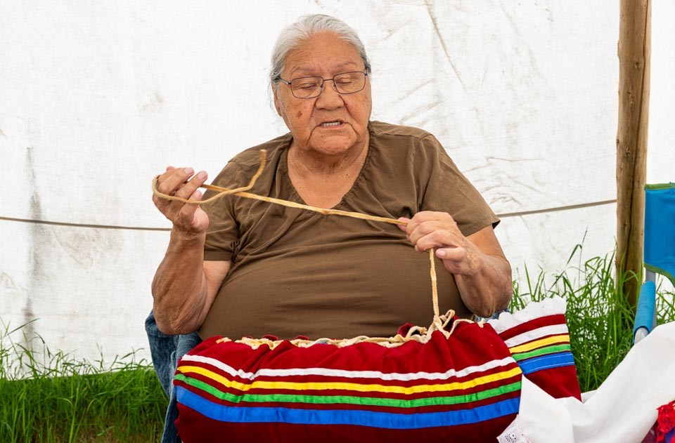 Mary Kahpeaysewat shows the leather strap that represents the umbilical cord. 