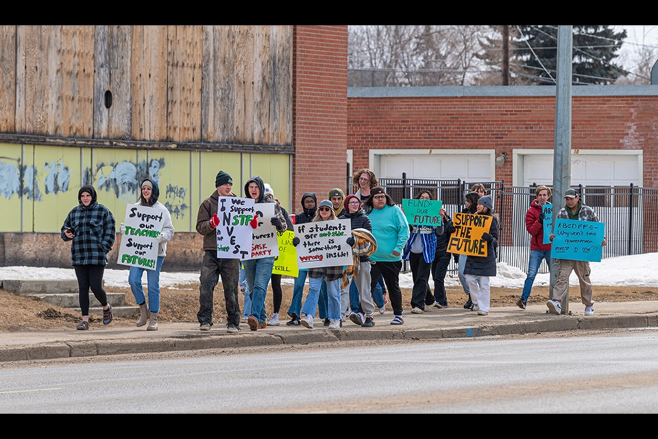 Students march down 100th Street.