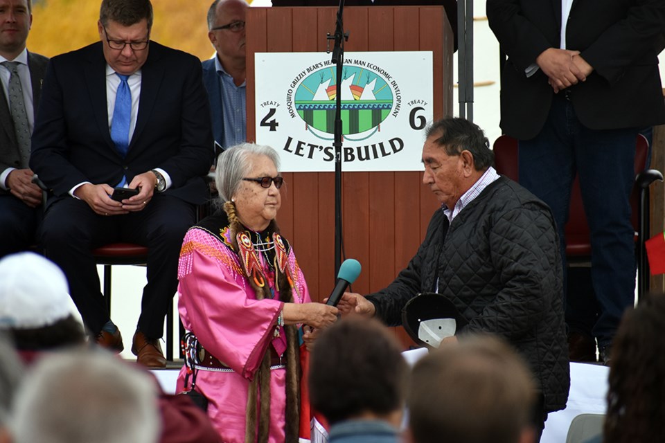 FSIN Senator Jenny Spyglass passes the microphone to an Indigenous elder to pray after she spoke and prayed at the start of the ceremony.