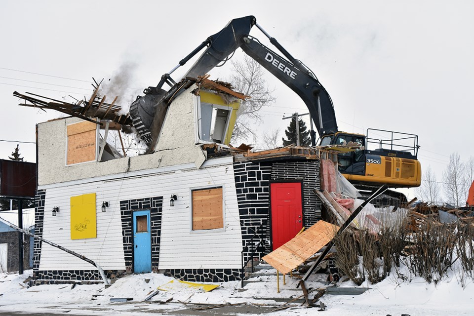 The Queen's Hotel in Battleford pictured as its demolished, the roof caving in as debris flies into the street.