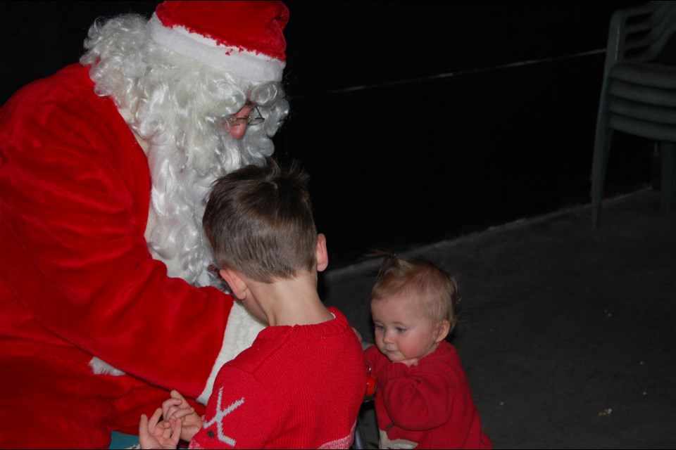 Wilfred Neumeier watches Santa ringing the bells for little sister, Brier.