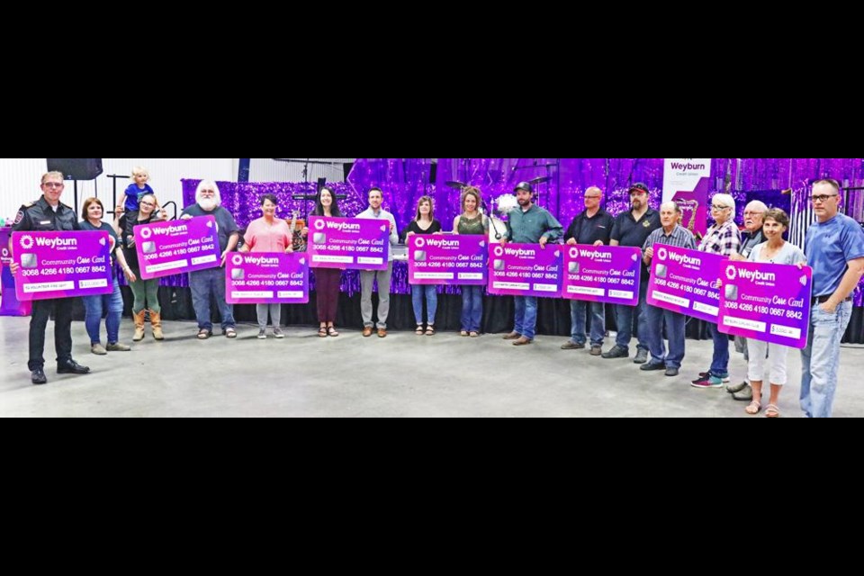 Nine community organizations and groups gathered after receiving just under $60,000 in Community Fund grants from the Weyburn Credit Union on Tuesday evening at the Weyburn Curling Rink. From left is the Yellow Grass Fire Department, $20,000; the Weyburn Humane Society, $10,000; the Family Place, $6,935; Saskatchewan Health Authority-City of Weyburn, $5,000; Colour My World Child Care, $2,500; Goodwater Community Centre, $2,500; Lang Volunteer Fire Department, $5,000; Prairie Memories Museum, Fillmore, $2,500; and the Weyburn Curling Club, $5,000.