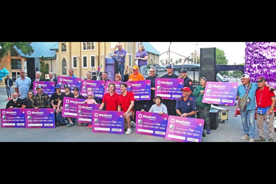 Representatives of 14 community groups and organizations gathered after they were presented with community grants at the Weyburn Credit Union's barbecue and concert night on Friday.