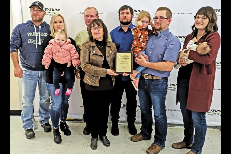 Ashworth Farm and Ranch of Oungre was presented with the 2023 Golden Sheaf Award by the Weyburn Chamber of Commerce, at the Ag Appreciation Banquet on Tuesday evening at McKenna Hall. From left to right are Brad and Brittany Storle and baby Everleigh; Kelly and Janice Ashworth; Owen Ashworth; Kyle Ashworth, holding Payton, and his wife Kelsey, holding Reegan. The family has a large grain and cattle operation, including 400 head of Simmental cattle.