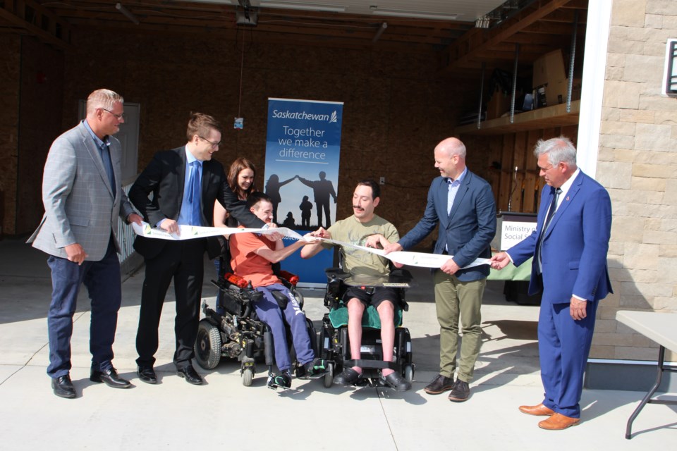 An official ribbon cutting was held for the new Weyburn Group Home, located at 137 DeLaet Drive, right after a barbecue and tours of the new residence were held on September 8. From left are Colin Folk, executive director, Weyburn Group Homes Society; Stephen Schuck, board chair; Tristan; Jodie Downton, support worker; Katlan; Dustin Duncan, MLA Weyburn-Big Muddy, and Mayor Marcel Roy.