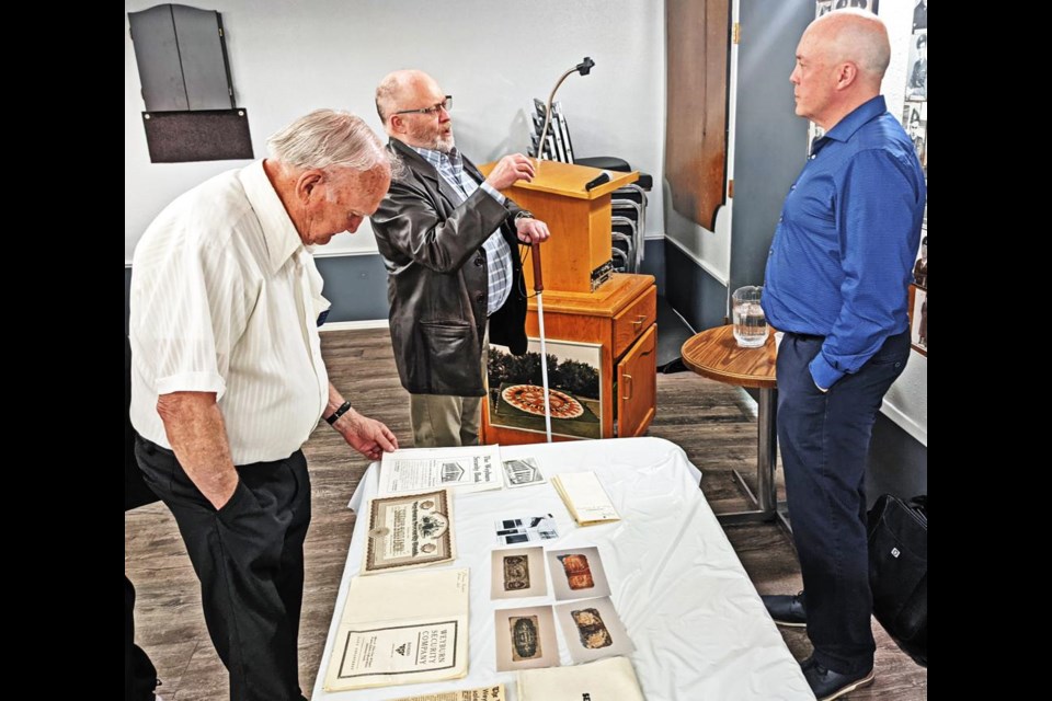 Rotary member Stafford Nimegeers, left, looked over the historical items on display, as fellow Rotarian Duane Schultz chats with Jim Onstad (right), managing director of Weyburn Security Company