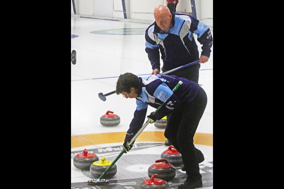Skip Danette Tracey sweeps a rock after it was hit by one of her players, during the Weyburn OTS bonspiel on Friday evening