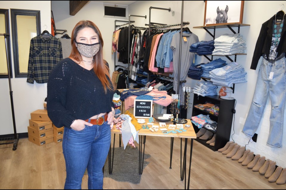 Owner Trinity Slykhuis poses alongside some of the items offered in her new business Rising Moon Collective. 
