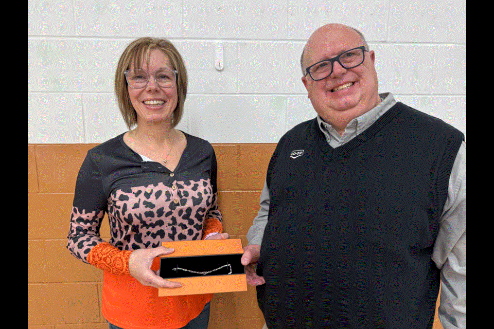 From left to right, Renea Van De Woestyne received a silver bracelet from Deric Reaney for her 10 years at Stoughton Co-operative. 