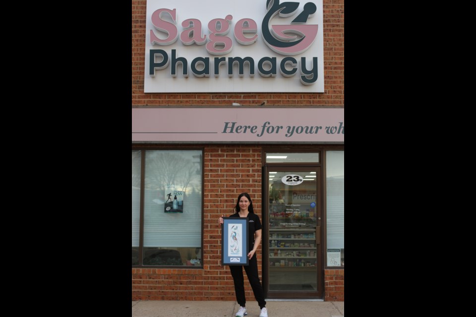 Melody Kelts, pictured here with her award from SIEF in front of Sage Pharmacy, located at 23 Smith Street West.
