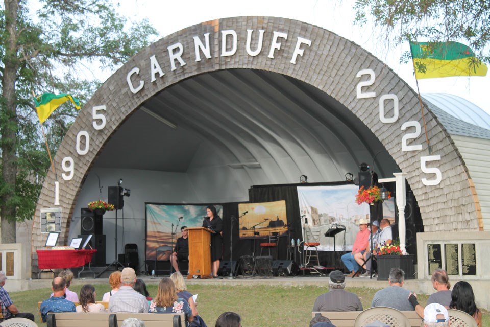 MC Tara Beck, addressing the crowd from the homecoming stage.