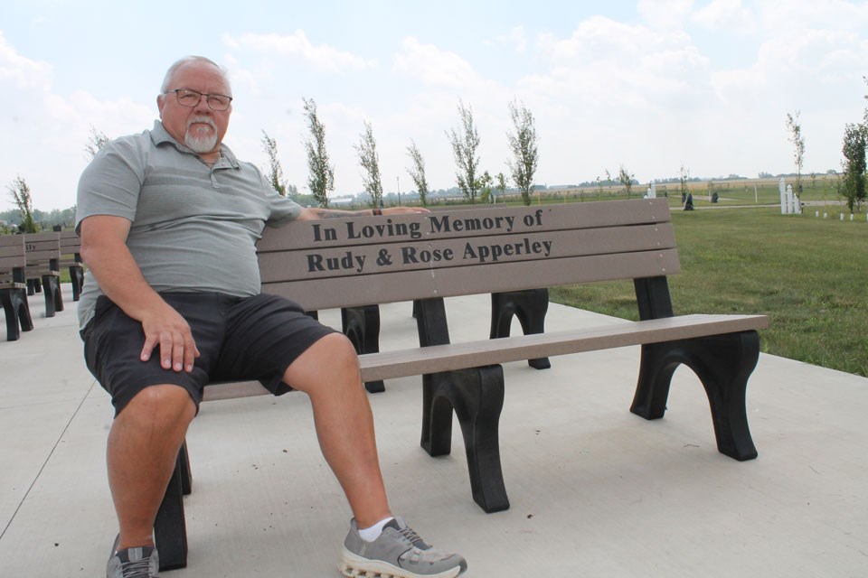 Mayor Ross Apperley on the memorial bench for his parents, who instilled his “cemetery passion.” 