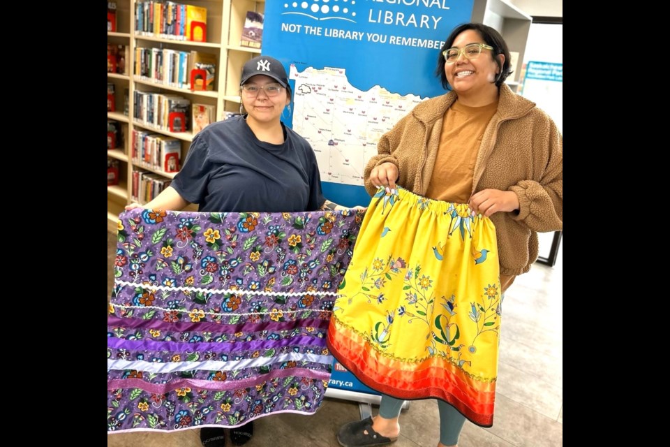 From left, Da-Yona Lonechild and Heather Sparrow, both from the White Bear First Nations, show their beautiful ribbon skirts made at the Carlyle Public Library. 