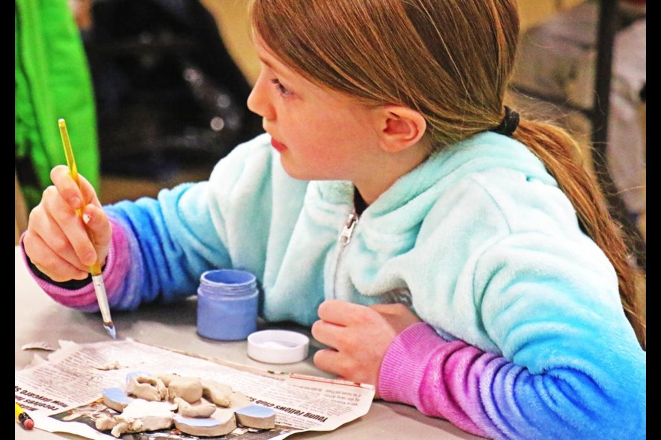 Bria took a break from painting her clay clown face, during Feb. break camp on Wednesday.