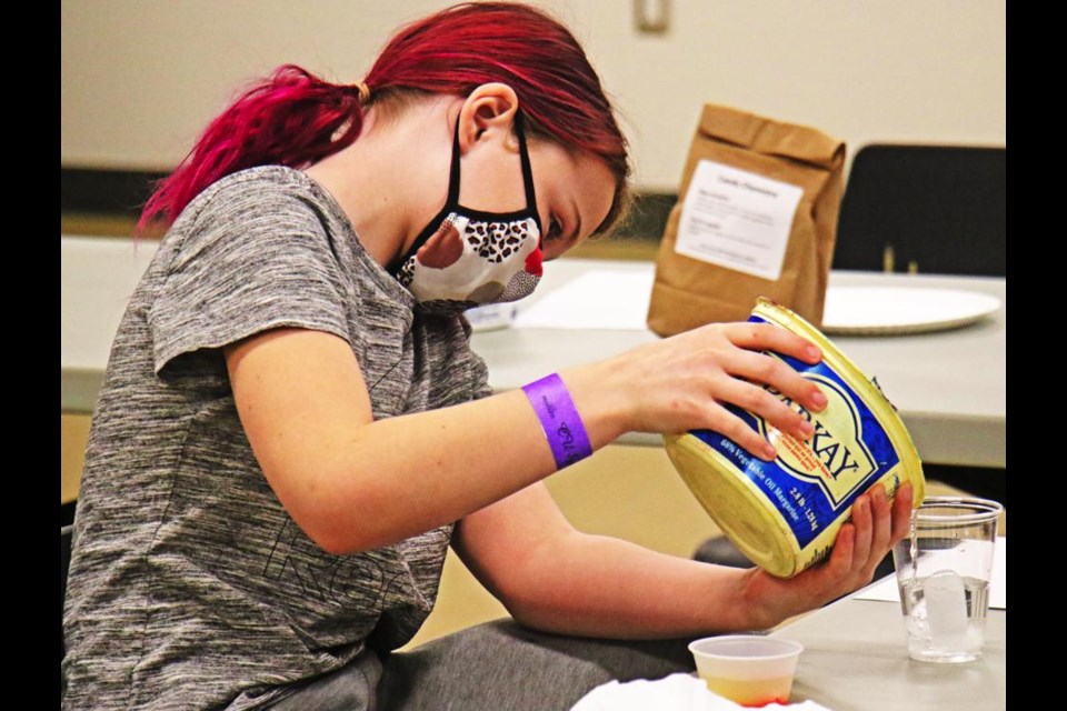 Jayden Stewart carefully measured out water for the next experiment in the "Candy Chemistry" STEM class held at the CU Spark Centre.