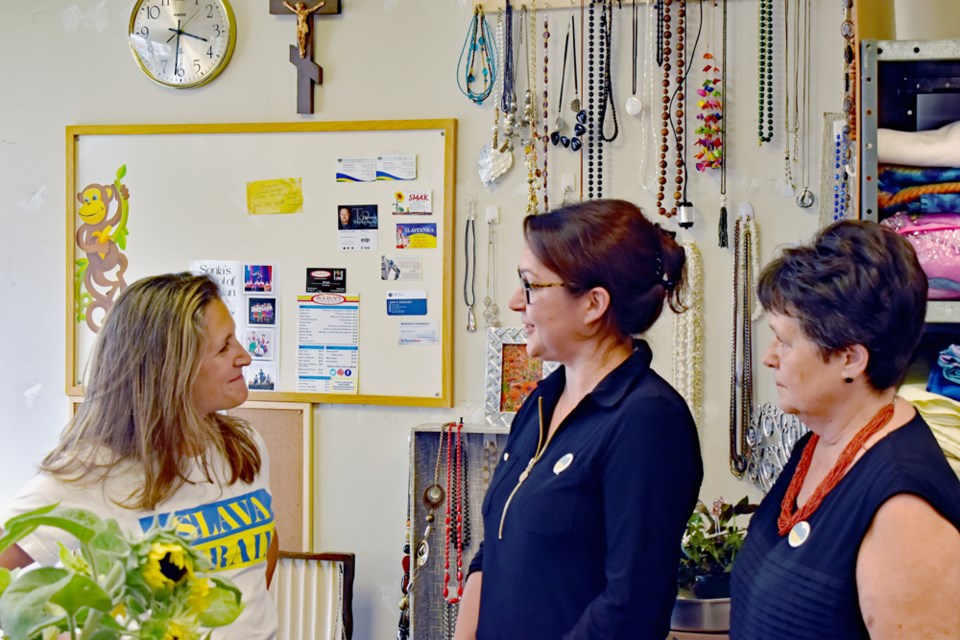 Baba's Closet coordinator Nettie Cherniatenski, right, and Irina Dudka, centre, greet Deputy Prime Minister Chrystia Freeland as she drops off some donations at Baba's Closet.