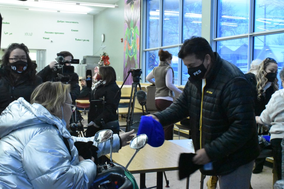 Federation of Sovereign Indigenous Nations Chief Bobby Cameron, right, hands over some winter clothing to a client of Friendship Inn on Wednesday morning.