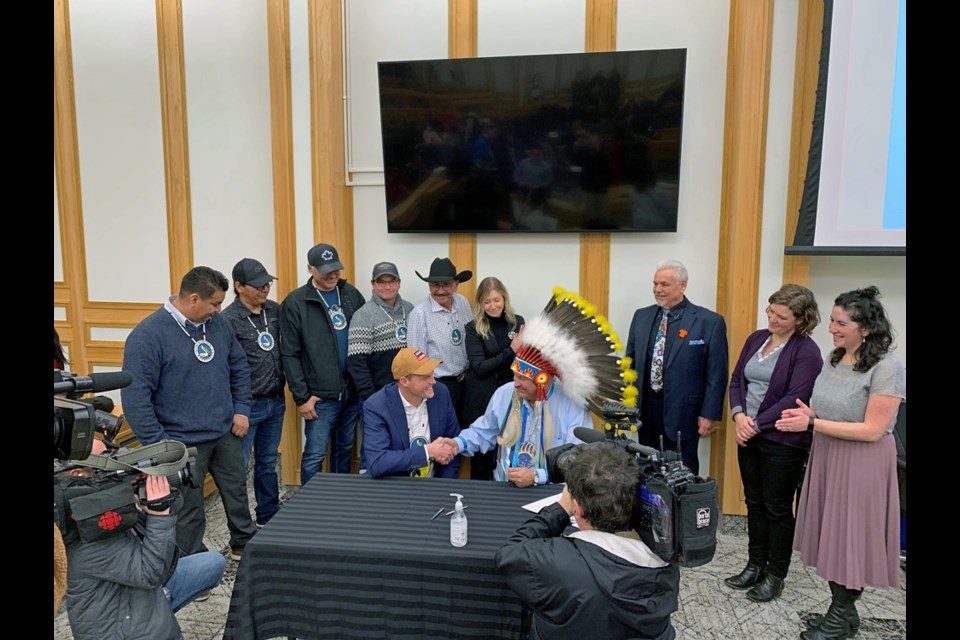 Pelican Lake First Nation Chief Peter Bill, seated right, shakes the hand of Saskatoon Mayor Charlie Clark after the historic signing last week. 