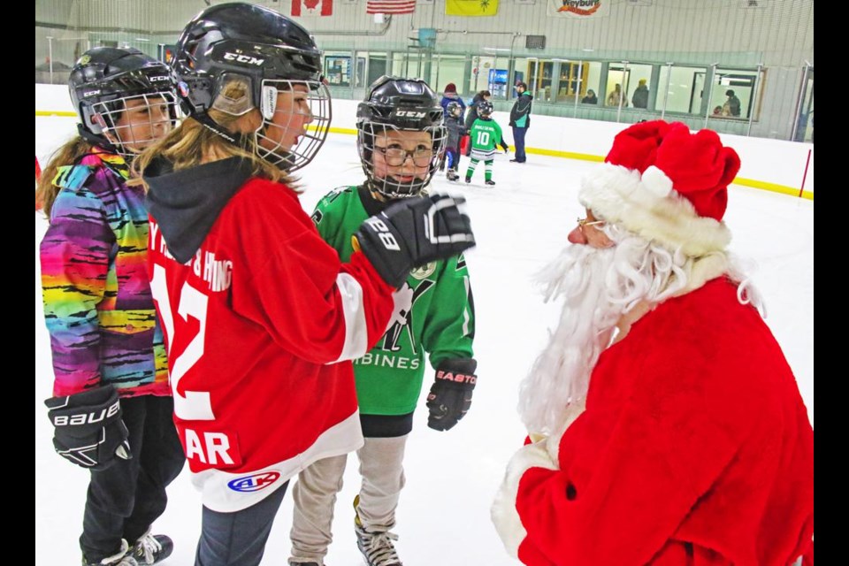 Santa got down to eye level to chat with these three girls, Reese Chicoine, Aubrey Cossar and Suri Seghers, at the Skate with Santa event on Sunday afternoon.