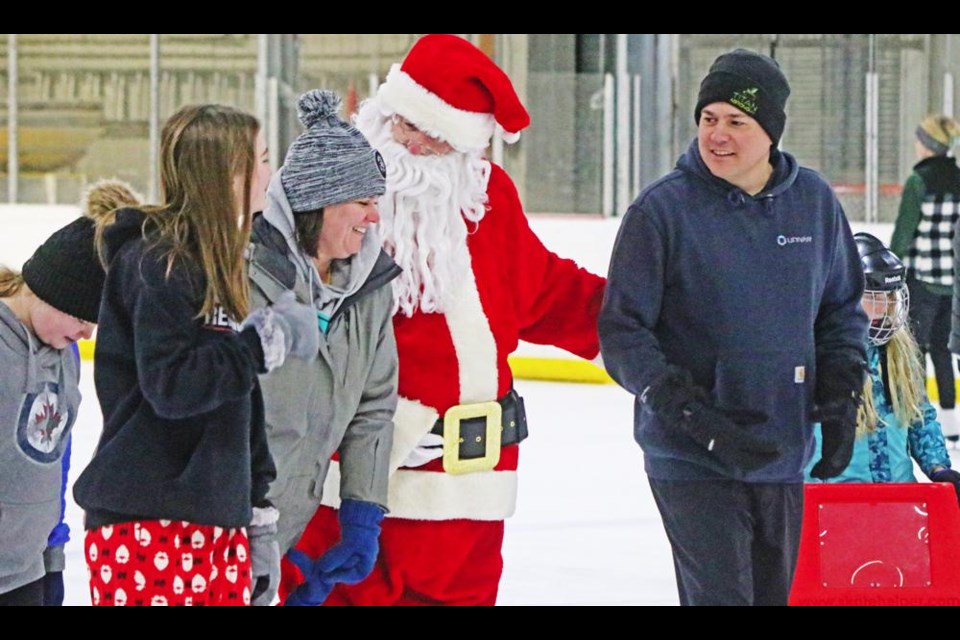 Santa visited with a family while skating before stopping for a photo with them at Weyburn's Skate with Santa event on Sunday.