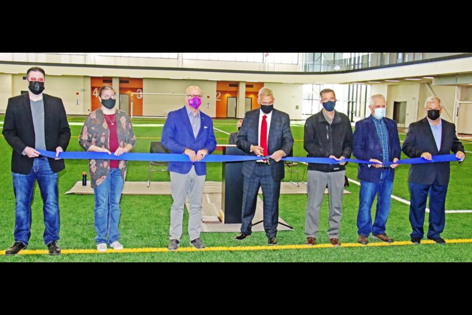 Members of Weyburn city council lined up for the ribbon-cutting for the Spark Centre, including from left, councillors Ryan Janke, Laura Morrissette, Jeff Richards, Mayor Marcel Roy doing the honours, Mel Van Betuw, Dick Michel and John Corrigan.