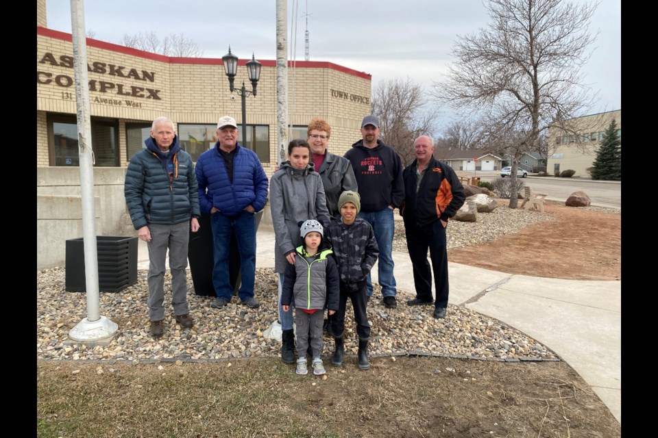 Iryna Kenes and her two sons stand among Town Council members, during a Ukrainian flag raising. In the back row, from left, are Graham Harvey, Peter Kordus, Mayor Sharon Schauenberg, Kent Fettes and Clint Mauthe.