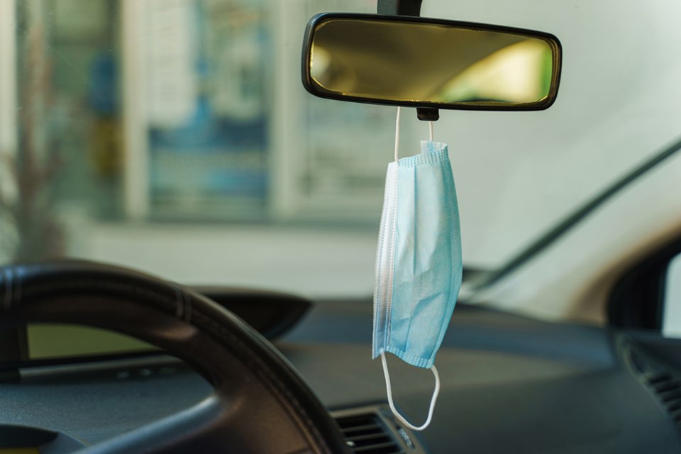 covid mask hanging from rear view mirror