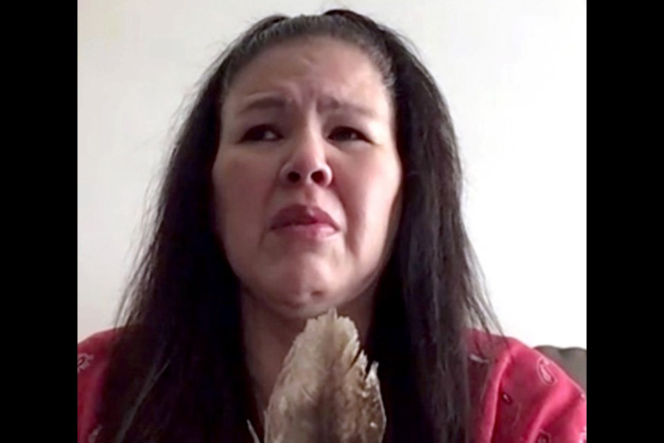 Odelia Quewezance holds an eagle feather as she proclaims her innocence during a zoom media conference in May 2021. When First Nations hold an eagle feather it signifies they are speaking the truth because the eagle feather represents honesty. 