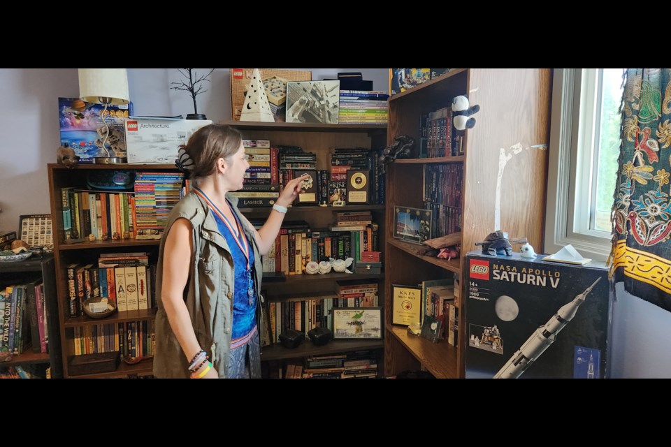 Jennifer Webb shows the books that she accumulated that can be read in the library.