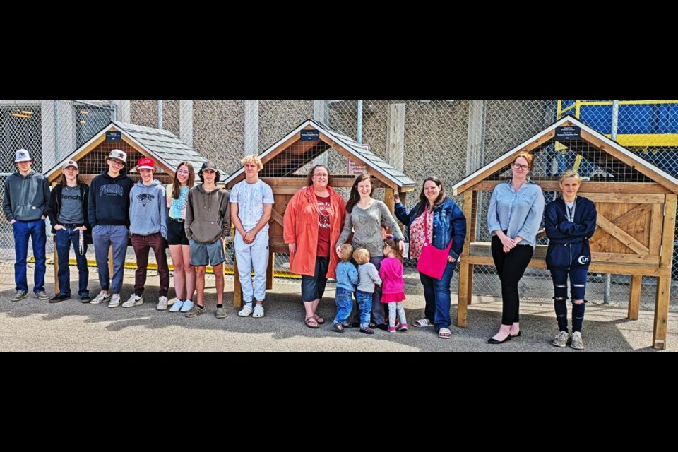 Students from the Construction 20 class at the Weyburn Comprehensive School gathered with board members from the Weyburn Therapeutic Animal Park, as they handed over these three rabbit hutches for the park on Wednesday. From left are students Connor, Davin, Kai, Braxton, Kristin, Jacob and Haydin, and board members Denise Kennedy, president Kristy Frayn and children Maverick, Molly and Otto; secretary-treasurer Janelle Stang, Sara Shier and Naomi Carson.