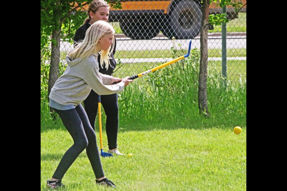 Destah Kittelson shot her ball as Henlee Brown watched, during the Gr. 5-6 golf time on Wednesday at APES.