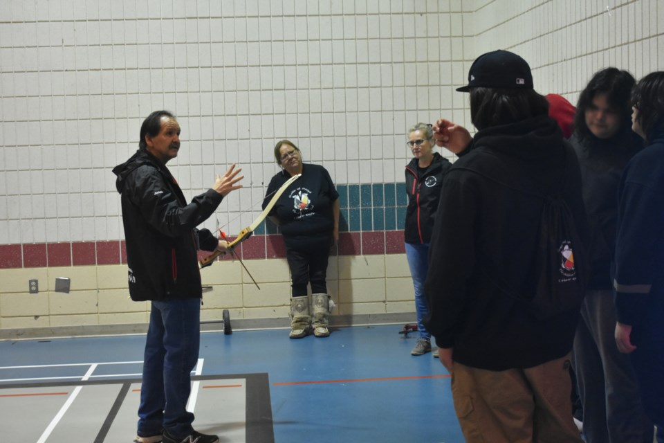 Far left, Jonas Cote taught students how to fire a bow, students would practice with a longbow and compound bow.
